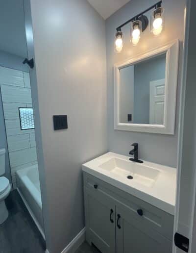 Alternate angle of the Bryn Mawr bathroom remodel by MM Home Improvements, showing the new tub, 3D wave effect tile, and a light-up niche