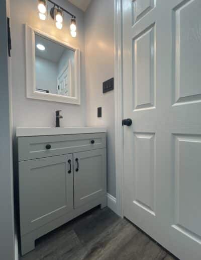 Small bathroom remodel by MM Home Improvements in Bryn Mawr, featuring carefully selected colors, a medicine cabinet, and black hardware.