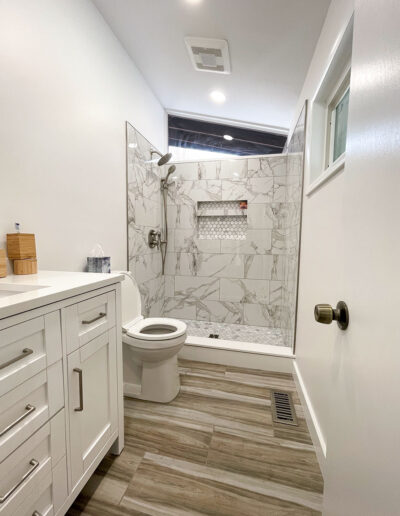 Small bathroom remodel in Malvern with a niche and mitered tile edges on the niche and shelf.