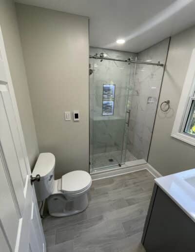 Small bathroom remodeled by MM Home Improvements featuring a light-up niche in Haverford